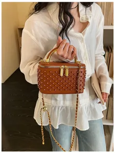 Detailed view of brown beaded box handbag with gold handle and chain strap for stylish women.