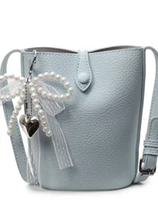 Petit sac bandouliere en cuir bleu clair avec noeud en perles et pendentif chic pour l'ete.