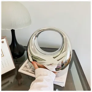 Bolso de mano plateado para mujer con diseño de anillo hueco, elegante accesorio.