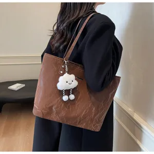 Stylish large capacity tote bag for women, casual brown shoulder bag with cute cloud plush pendant.