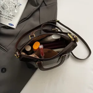 Detailed view of structured brown vintage crossbody tote bag interior filled with cosmetics.