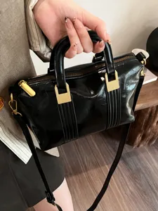 Vintage black patent leather handbag with top handles and shoulder strap for women commute.