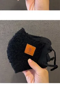 Black plush winter face mask detail showing soft sherpa texture and adjustable ear straps.