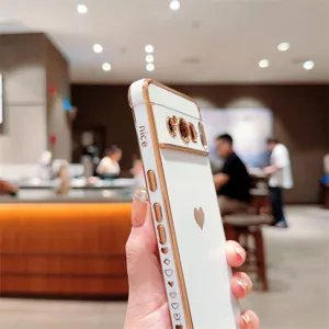 Vue détaillée de coque de téléphone électrodécorée en blanc et or rose avec motif cœur.