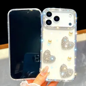 Detalle de funda para teléfono con corazón de pedrería brillante y cuentas de perlas.
