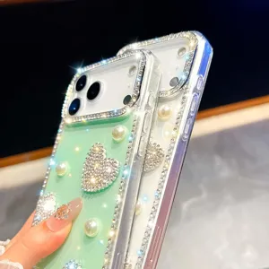 Detalle en primer plano de funda de teléfono brillante con pedrería y diseño de corazón.