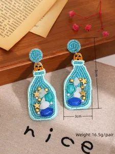 Vue rapprochée de boucles d'oreilles de bouteille de style océan en perles artisanales.