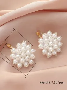 Gros plan détaillé des boucles d'oreilles en perles, mettant en valeur le design floral.