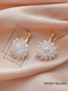 Gros plan détaillé de boucles d'oreilles fleuries en cristal avec des perles étincelantes.
