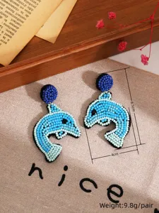 Boucles d'oreilles dauphin en perles fait main vue detail, style plage ete mode.