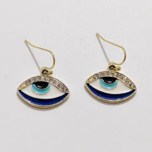 Close-up detail of trendy evil eye hook earrings featuring sparkling rhinestones and colorful enamel.