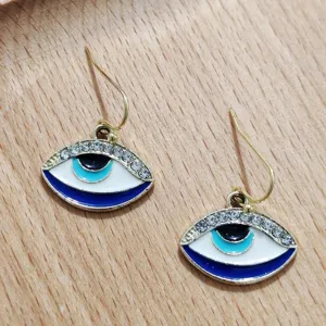 Close-up detail shot of evil eye earrings featuring blue and white enamel with sparkling rhinestones.
