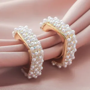 Detailed shot of trendy geometric pearl crystal gold-plated hoop earrings, light luxury design.