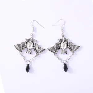 Detailed view of vintage silver bat earrings with black crystal pendant, gothic design.