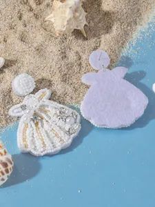Dettaglio ravvicinato di orecchini con conchiglie di perline, stile spiaggia estiva.