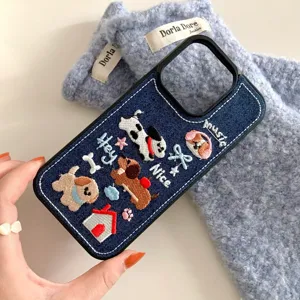 Detaillierte Nahaufnahme des süßen bestickten Hundemusters auf der blauen Jeans Handyhülle.