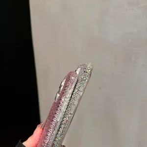 Luxury rhinestone iPhone case detail close-up showcasing sparkling pink crystals and precise button cutouts.