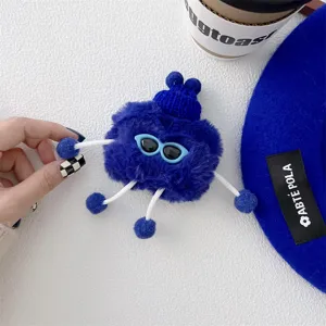 Detailed view of the cute blue plush sunglasses monster AirPods case with funny limbs design.