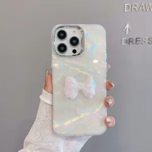 Pearlescent shell phone case with cute 3D bow detail and electroplated camera protection.