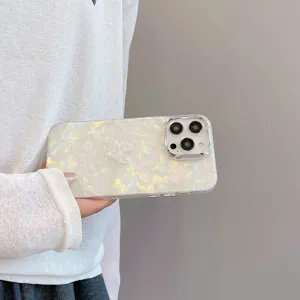 Pearlescent shell texture phone case detail showcasing glitter heart and camera frame.