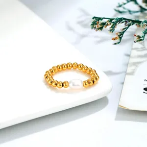 Close-up of gold beaded ring with central freshwater pearl and elastic band design.