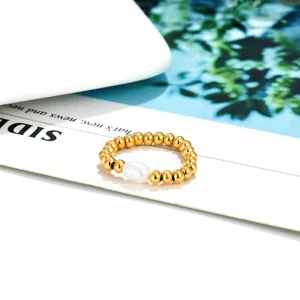 Gold beaded ring detail featuring a polished natural freshwater pearl on elastic cord.