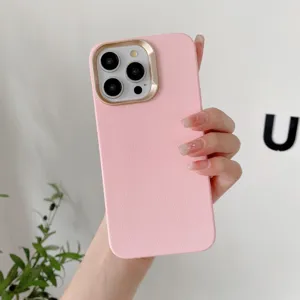 Détail rapproché de la coque de téléphone rose en similicuir avec cadre de caméra doré.