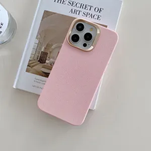 Gros plan sur la coque de téléphone en similicuir rose avec contour caméra doré sur livre.