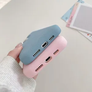 Bottom detail view of liquid silicone phone cases in blue and pink with precise port cutouts.