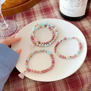 Closeup detail showing sweet fresh style beaded gemstone bracelets with cute crystal pendants.