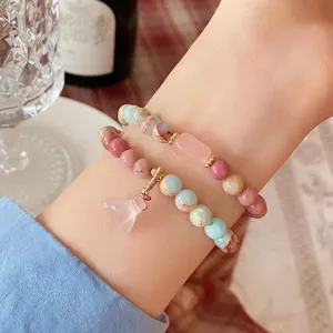 Close-up detail of sweet fresh style multi-layer gemstone bracelet with pink crystal lotus pendant.