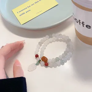 Detailed view of Chinese style multi-layer jade beaded bracelet with charming pendant.