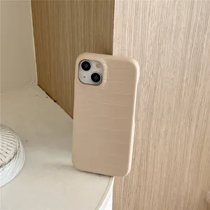 Primer plano detallado de funda de móvil beige con motivo cocodrilo en superficie de madera.