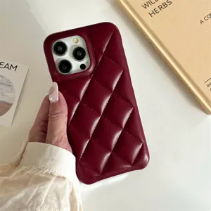 Close-up of quilted wine red leather phone case detail, stylish soft texture surface.