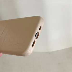 Vista detallada de una elegante funda de teléfono de cuero sintético con textura de cocodrilo.