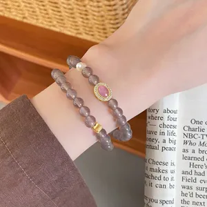 Close-up detail of multi-layer agate bracelet featuring pink gemstone and chic gold accent beads.