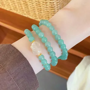 Elegant multi-layer green beaded bracelet with carved jade pendant for women Chinese style jewelry detail.