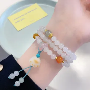 Detailed shot of multi-layer Chinese style jade bead bracelet featuring lucky cat charm.