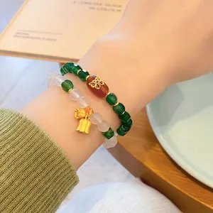 Close up detail of Chinese style natural agate multi layer bracelet with golden butterfly charm.