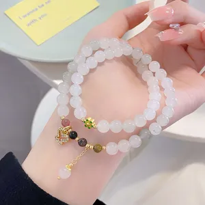 Detailed view of Chinese style multi-layer natural stone bead bracelet with charming pendants.