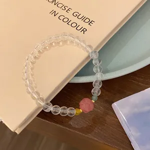 Élégant bracelet de perles en cristal blanc avec un joli accent de fleur sculptée rose.