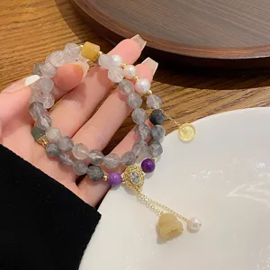 Close-up details of the multi-layer Chinese style gemstone bracelet with pearls and pendants.