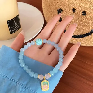 Detailed shot of refreshing light blue natural stone bracelet with cute pendant and beads.
