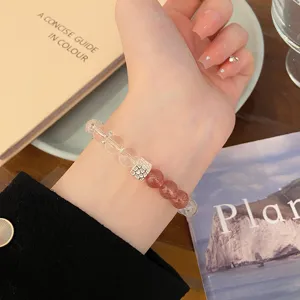 Détail de bracelet en cristal exquis avec quartz clair et perles roses et charm en métal.
