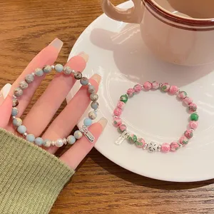 Detailed view of sweet natural stone beaded bracelets set with cute clover charm and pearl accents.