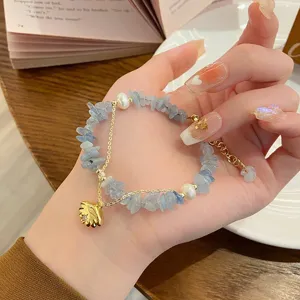 Detail shot of a refreshing blue natural stone chip and pearl bracelet with a cute gold charm.