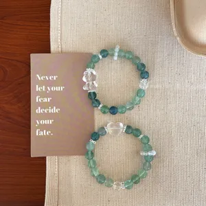 Natural mint green fluorite crystal beaded bracelets featuring cute bear and heart pendants, detail view.
