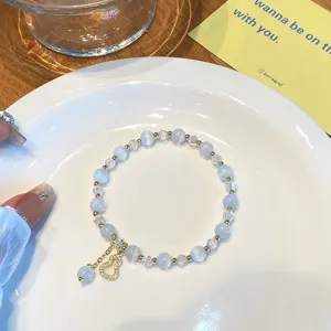 Detail de bracelet de perles en pierre bleue avec joli pendentif gourde dore.