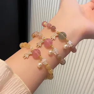Close-up detail of multi-strand crystal beaded bracelet with cute pave bear charm and pearls.