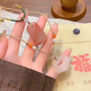 Vue détaillée du collier artisanal de style chinois avec des pendentifs en agate et jade.